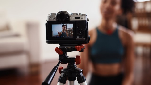 Article thumbnail: Shot of a young woman recording herself doing yoga at home