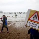 Article thumbnail: BRIGHTON, ENGLAND - MAY 18: Swimmers, paddle boarders and surfers take part in a 'paddle out' demonstration by Surfers Against Sewage off Brighton Beach on May 18, 2024 in Brighton, England. Surfers Against Sewage paddle-outs involve local communities coming together to protest against water companies dumping sewage in the oceans and rivers they use for watersports and swimming. (Photo by Jack Taylor/Getty Images)