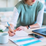 Article thumbnail: Young Asian women managing home finance using laptop & smartphone. She is working with household utility bill and calculating expenses at home.