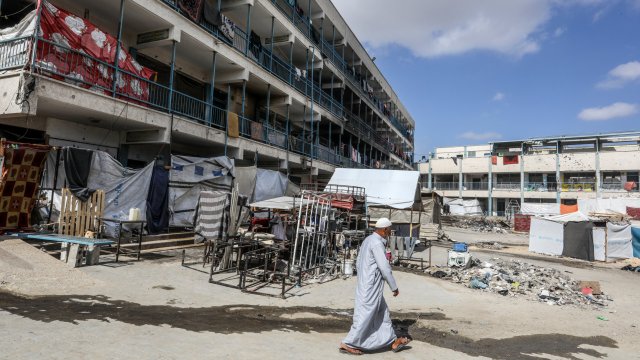 Article thumbnail: KHAN YUNIS, GAZA - JUNE 30: An elderly Palestinian man walks past a school belonging to the United Nations Relief and Works Agency for Palestine Refugees in the Near East (UNRWA), which was heavily damaged in the Israeli army attack, becoming a shelter for the displaced Palestinians in Khan Yunis, Gaza on June 30, 2024. (Photo by Abed Rahim Khatib/Anadolu via Getty Images)