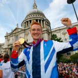 Article thumbnail: LONDON, ENGLAND - SEPTEMBER 10: British Olympic gold medal winning athlete Greg Rutherford holds his long jump gold medal as he takes part in the parade passing St Paul's Cathedral during the London 2012 Victory Parade for Team GB and Paralympic GB athletes on September 10, 2012 in London, England. (Photo by David Davies - WPA Pool/Getty Images)