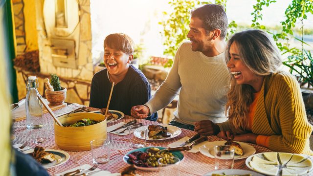 Article thumbnail: Happy latin family having fun eating together during home dinner - Soft focus on father hands