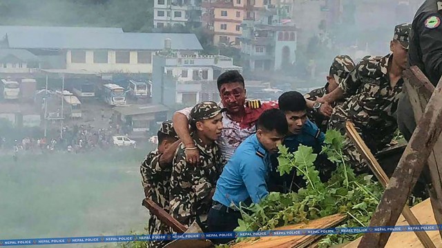 This handout photograph taken on July 24, 2024 and released by Nepal Police shows rescuers carrying the injured pilot of Saurya Airlines' plane after it crashed during takeoff at the Tribhuvan International Airport in Kathmandu. A passenger plane crashed on takeoff in Kathmandu on July 24, with the pilot rescued from the flaming wreckage but all 18 others aboard killed, police in the Nepali capital told AFP. (Photo by Nepal Police / AFP) / RESTRICTED TO EDITORIAL USE - MANDATORY CREDIT "AFP PHOTO / Nepal Police" - NO MARKETING NO ADVERTISING CAMPAIGNS - DISTRIBUTED AS A SERVICE TO CLIENTS - NO ARCHIVE (Photo by -/Nepal Police/AFP via Getty Images)