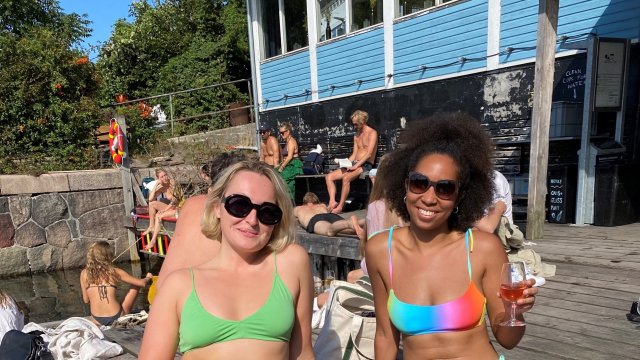 Article thumbnail: Journalist Lakeisha Goedluck (right) sitting with a friend in bikinis with drinks at a swimming spot in Copenhagen