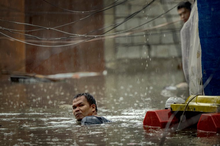 MANILA, PHILIPPINES - JULY 24: A resident wades floodwaters brought about by Typhoon Gaemi and monsoon rains on July 24, 2024 in Quezon city, Metro Manila, Philippines. Monsoon rains, intensified by Typhoon Gaemi, have caused flooding and landslides throughout the Philippines, resulting in at least eight deaths and displacing over 600,000 people. The typhoon, located east of Taiwan Wednesday with up to 162 kph winds, did not make landfall in the Philippines but enhanced monsoon rains. In the region around the capital Manila, government work and schools were suspended due to severe overnight flooding. (Photo by Ezra Acayan/Getty Images)