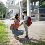 Article thumbnail: Mother talking with her son by the elementary school, it's her son's first day of school.